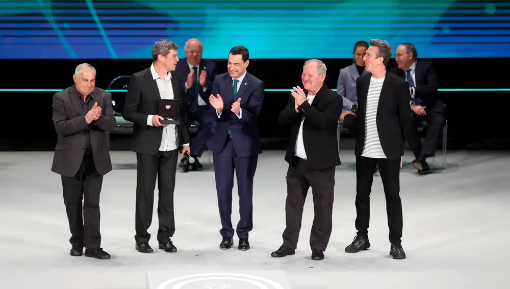 El presidente andaluz, Juanma Moreno, aplaude tras entregar la Medalla de Andalucía de las Artes al grupo musical Danza Invisible