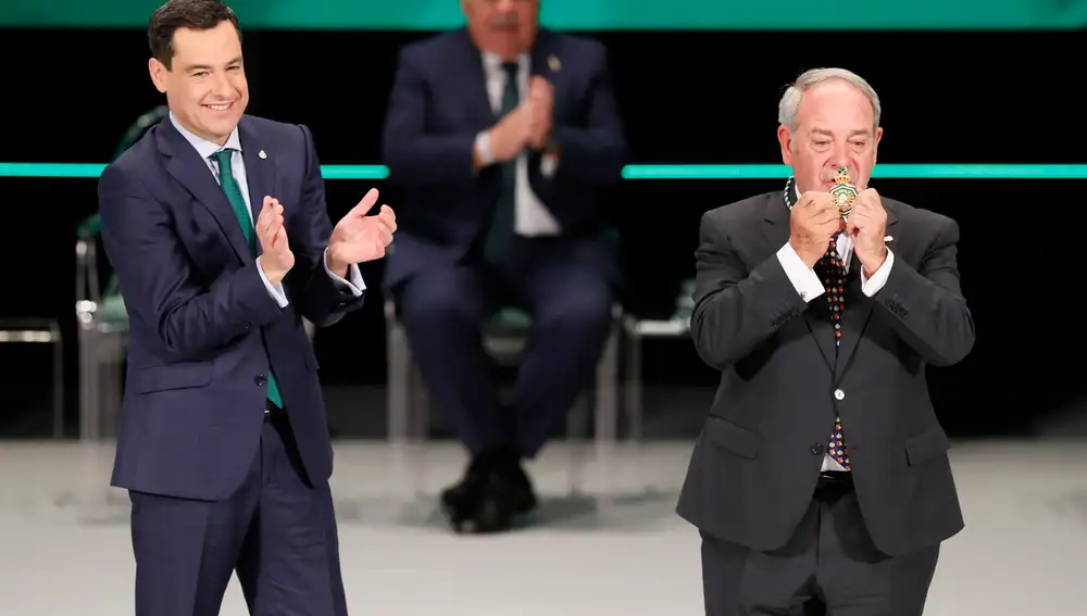 El presidente andaluz, Juanma Moreno, aplaude tras colocar la Medalla de Andalucía al Mérito Medioambiental al catedrático de la Universidad de Granada Manuel Titos