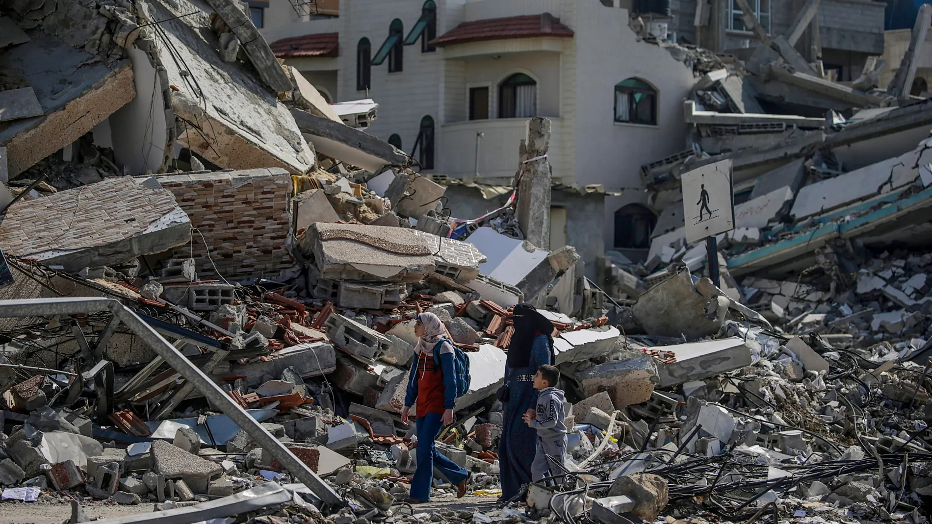 Al Nuseirat Camp (-), 28/02/2024.- A Palestinian mother walks with her children among the rubble of a destroyed residential building in Al Nuseirat refugee camp, central Gaza Strip, 28 February 2024, following Israeli air strikes. More than 29,900 Palestinians and over 1,300 Israelis have been killed, according to the Palestinian Health Ministry and the Israel Defense Forces (IDF), since Hamas militants launched an attack against Israel from the Gaza Strip on 07 October 2023, and the Israeli ...