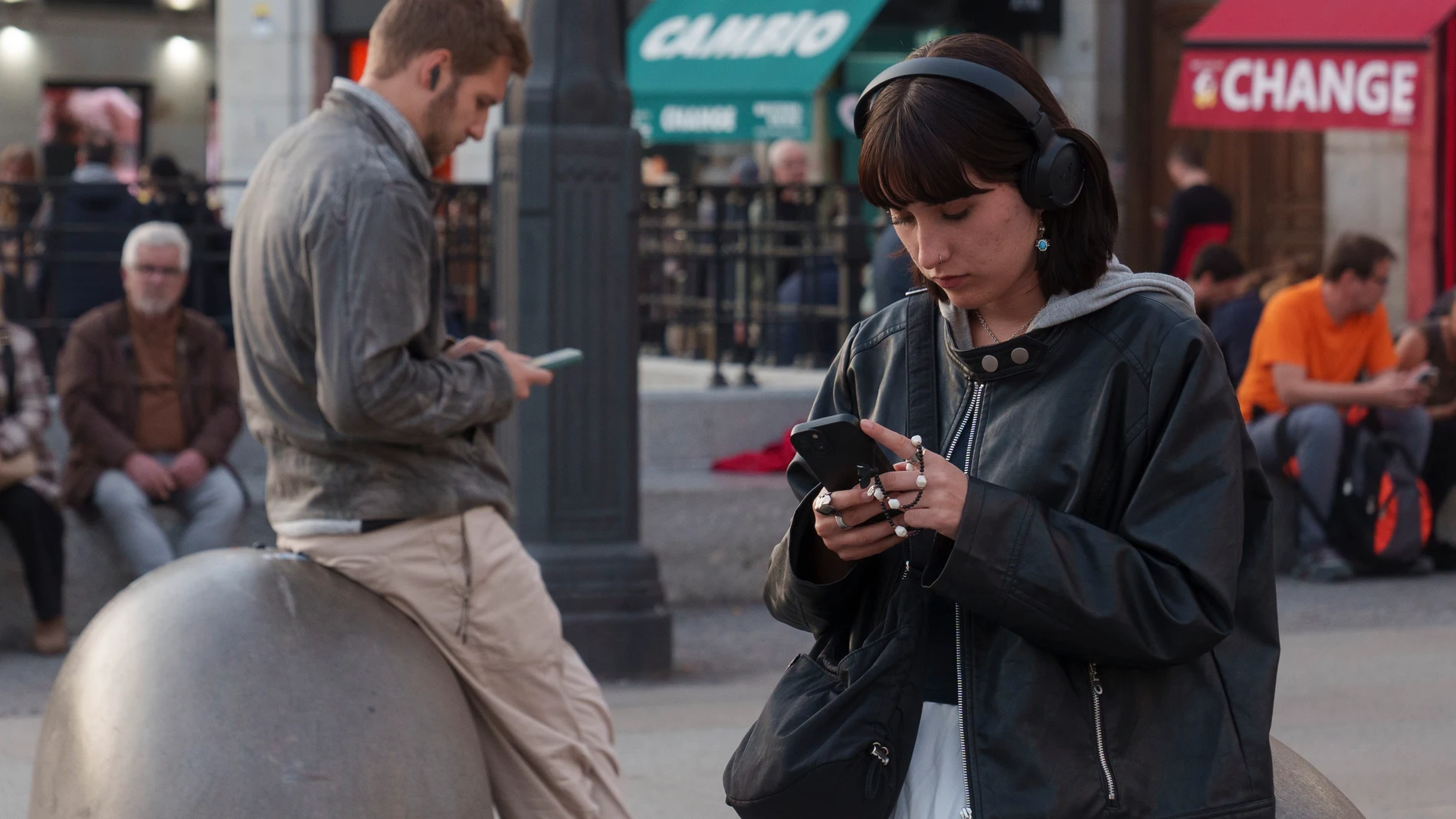 Una persona mira su movil en la Puerta del Sol.
