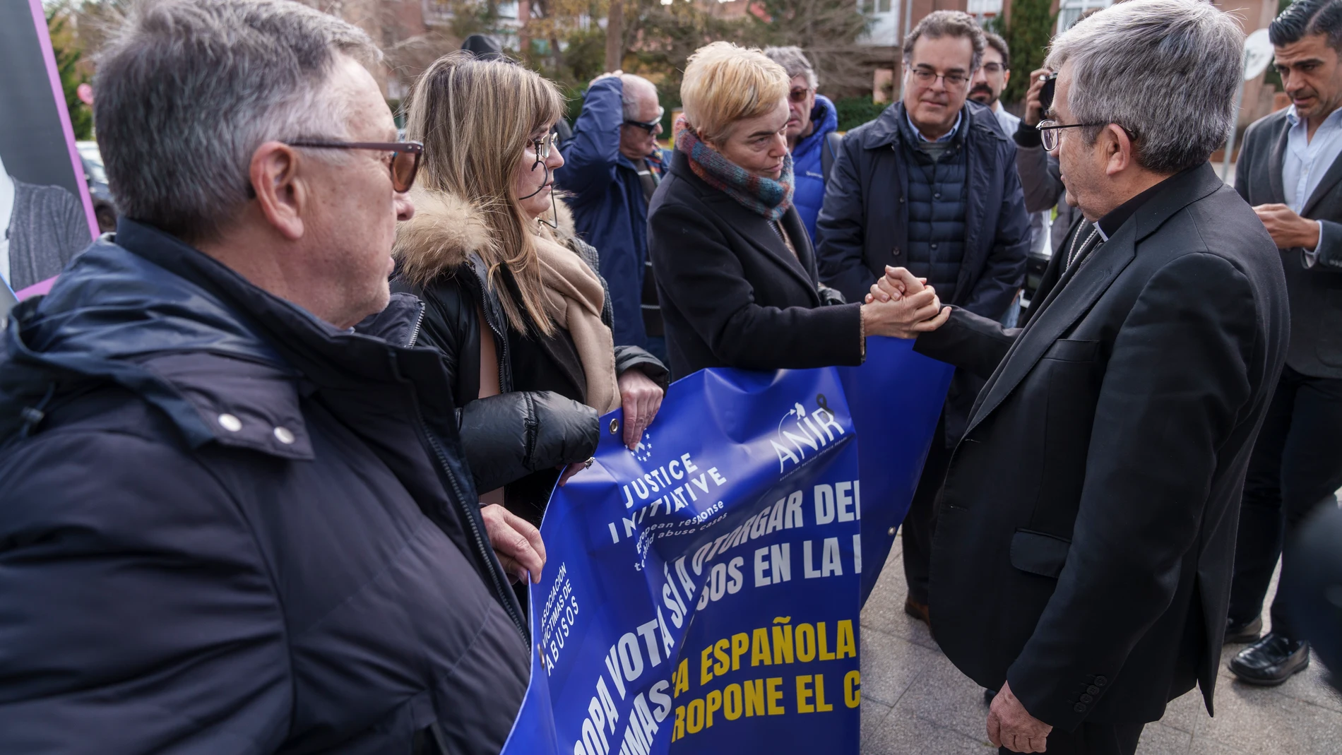 El presidente de los obispos, Luis Argüello, saluda a las víctimas de abuso que protestaron en la sede del Episcopado el 5 de marzo