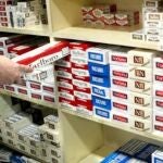 Empleado de un estanco con un cartón de tabaco en la mano