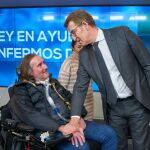 El líder del PP, Alberto Núñez Feijóo con una persona afectado por el ELA. 