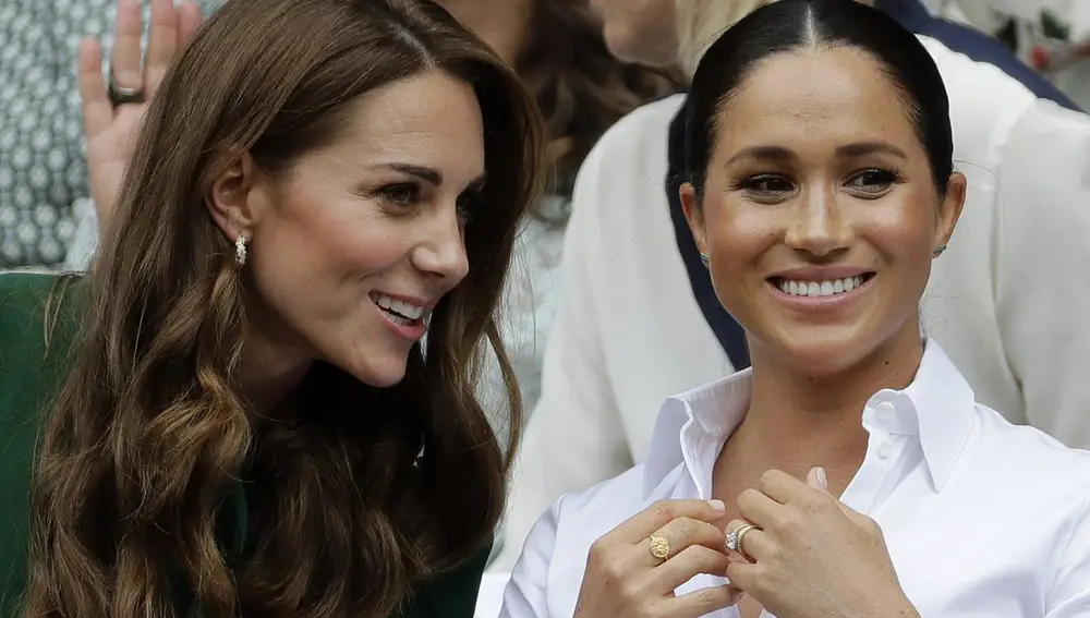 Britain's Kate, Duchess of Cambridge, left, and Meghan, Duchess of Sussex speak as they sit in the Royal Box on Centre Court