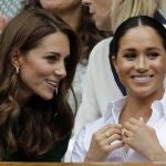 Britain's Kate, Duchess of Cambridge, left, and Meghan, Duchess of Sussex speak as they sit in the Royal Box on Centre Court