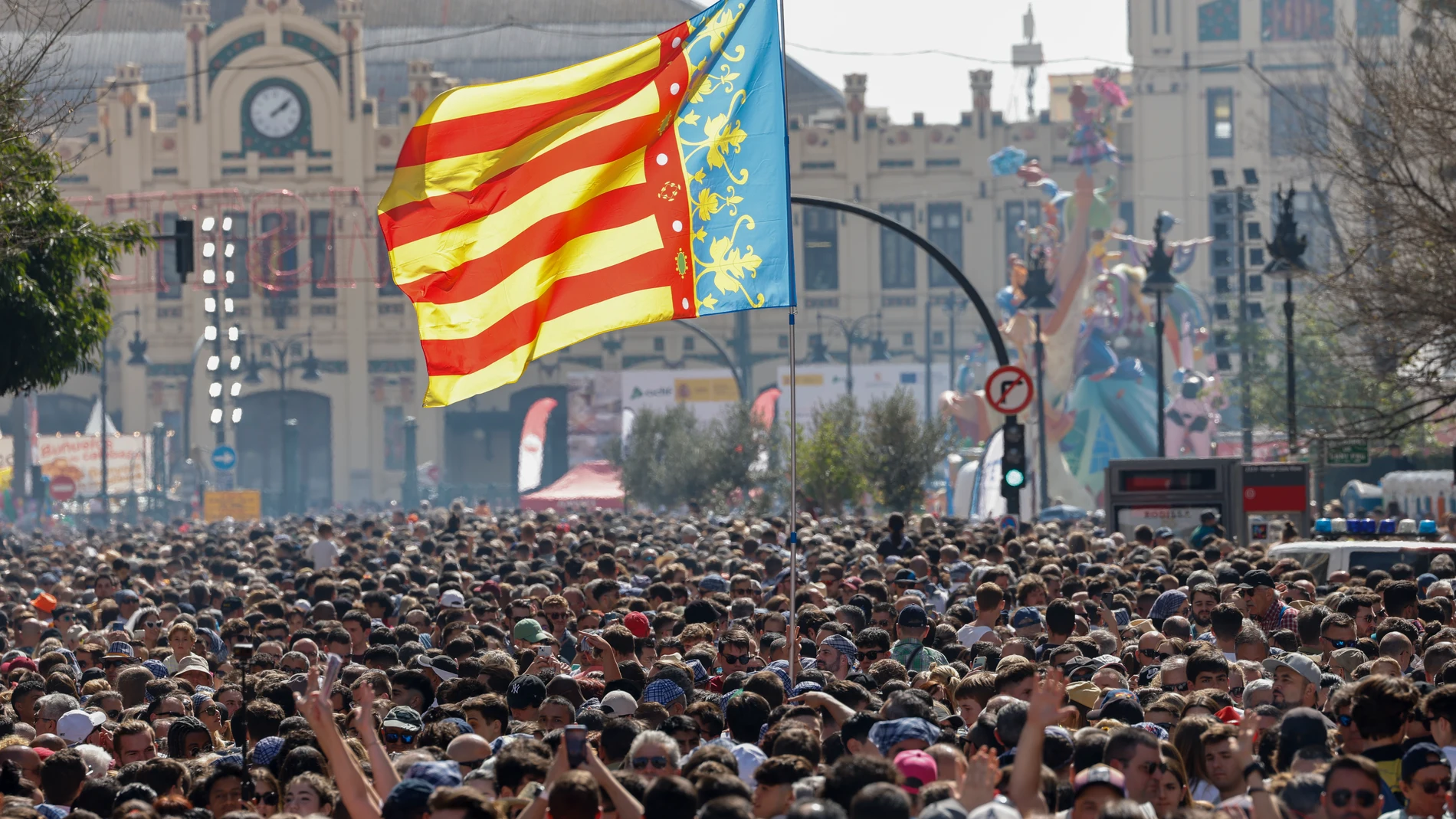GRAFCVA9312. VALENCIA, 17/03/2024.- La senyera valenciana ondea entre la multitud que asiste a la mascletà de las Fallas de 2024 disparada este domingo en la plaza del Ayuntamiento de València a cargo de Pirotecnia Caballer FX, de Moncada (Valencia). EFE/Ana Escobar