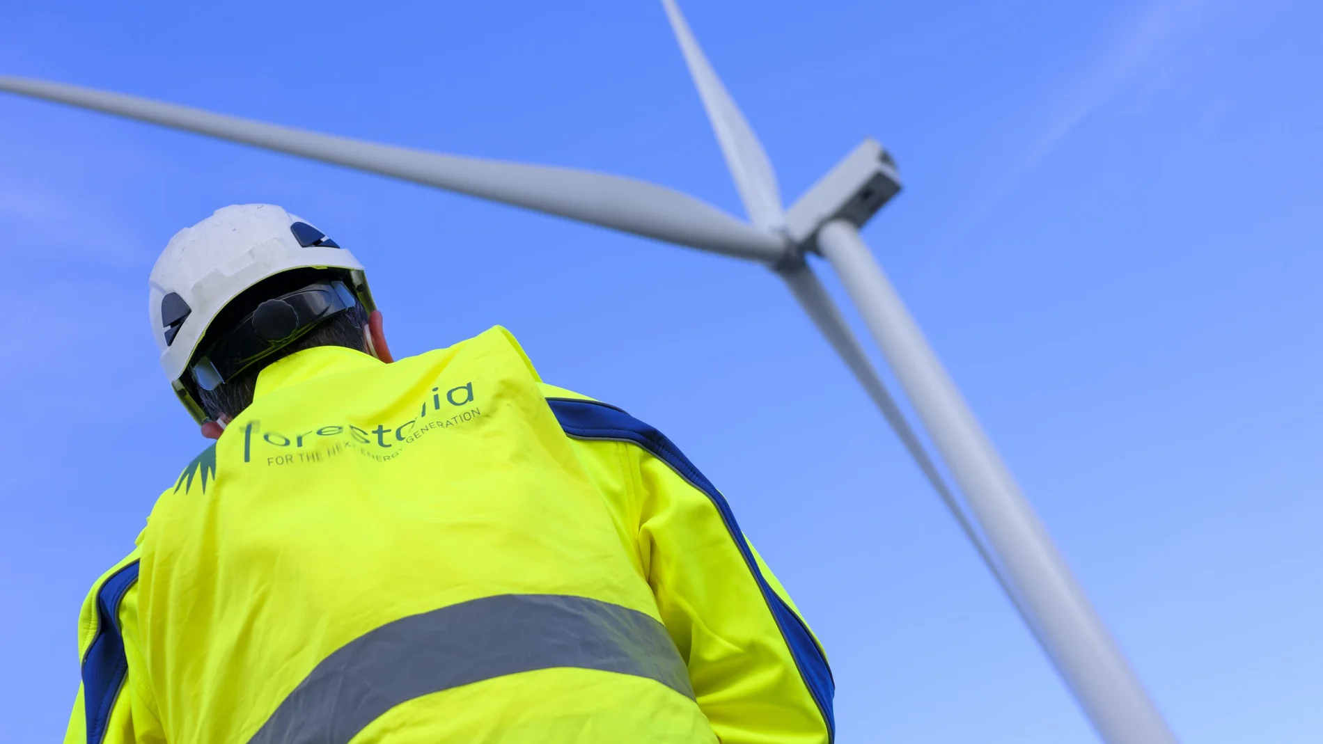 Un empleado de Forestalia junto a uno de los aerogeneradores de la compañía