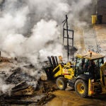 Una excavadora recoge las cenizas de la falla de la Plaza del Ayuntamiento
