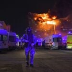 A Russian Rosguardia (National Guard) servicemen secures an area as a massive blaze seen over the Crocus City Hall on the western edge of Moscow, Russia, Friday, March 22, 2024. 