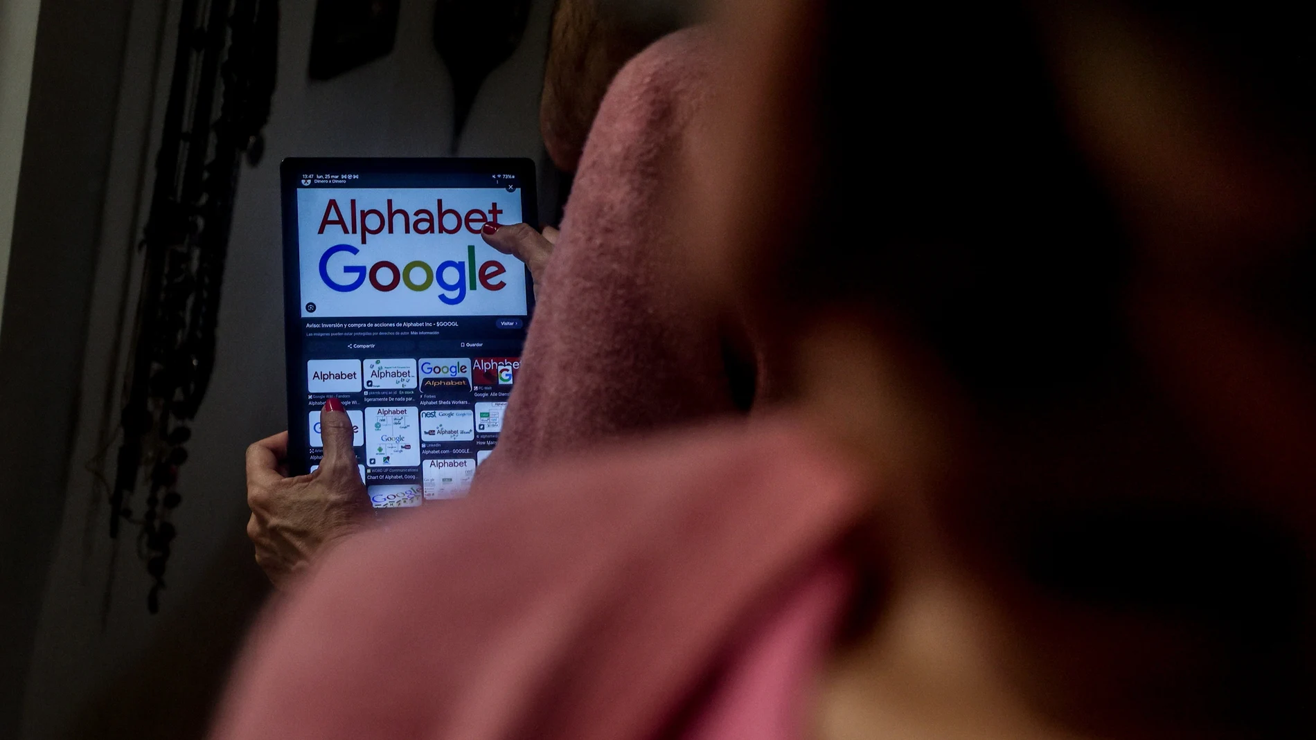 Una mujer con una tablet en la que pone Alphabet Google, a 25 de marzo de 2024, en Madrid (España). Bruselas lanza los tres primeros expedientes sancionadores, en virtud de la nueva Ley de Servicios Digitales, con el objetivo de poner fin al poder monopolístico de las grandes plataformas.