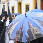 Nazarenos de la hermandad de Santa Genoveva, una de las nueve cofradías que salen en procesión el Lunes Santo en Sevilla, se dirigen a su templo este lunes en el que no procesionarán tras la decisión tomada debido a la lluvia que desde primera hora de la mañana cae en la capital andaluza.