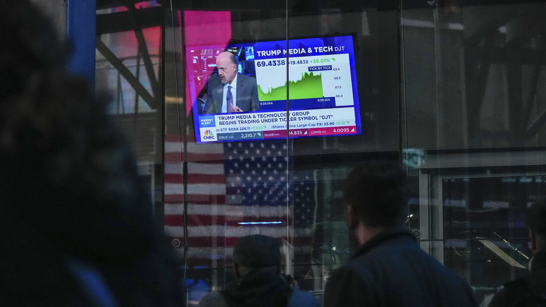 Peatones caminan junto a la Bolsa de Nueva York el día que empezó a cotizar la red social de Donald Trump