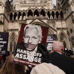 Demonstrators hold placards after Stella Assange, wife of Wikileaks founder Julian Assange, released a statement outside the Royal Courts of Justice, in London, Tuesday, March 26, 2024. Two High Court judges said they would grant Assange a new appeal unless U.S. authorities give further assurances about what will happen to him. The case has been adjourned until May 20. 