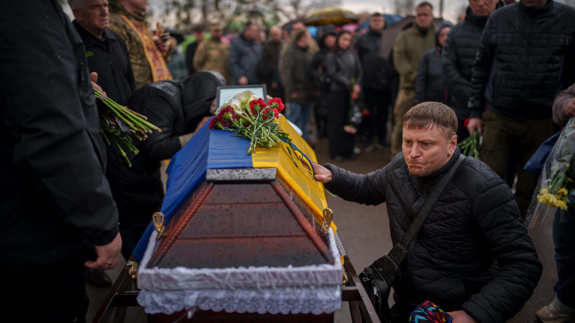 People pay their final respects to Ukrainian Cpt. Serhii Vatsko during his funeral in Boiarka, Ukraine, Friday, March 29, 2024. Vatsko, who was killed on the frontline of eastern Ukraine on March 24 joined the country's military in 2014. (AP Photo/Vadim Ghirda)