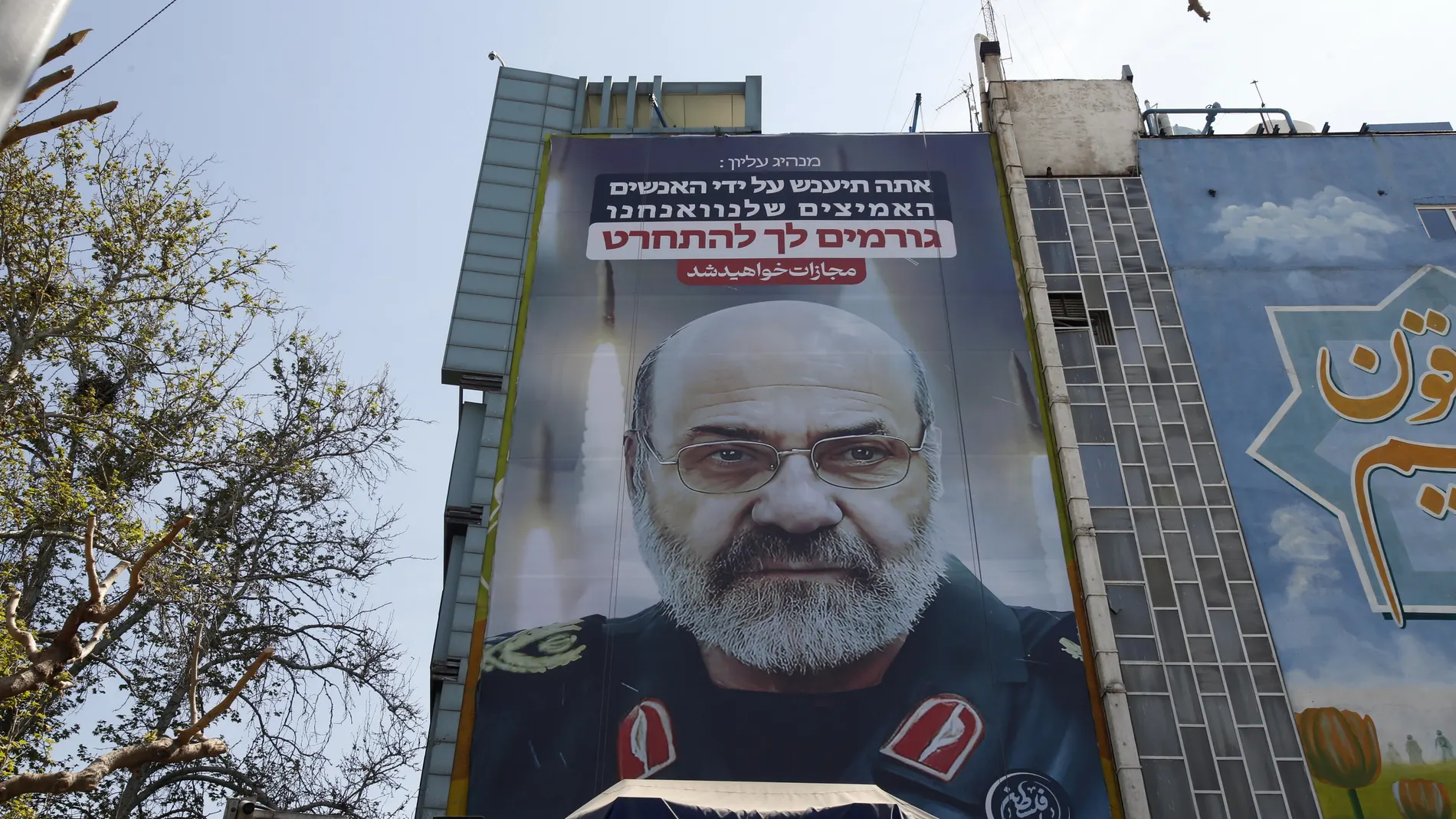 Tehran (Iran (islamic Republic Of)), 03/04/2024.- A large-scale billboard displaying a picture of Iranian Brigadier General Mohammad Reza Zahedi, a commander of the Islamic Revolutionary Guard Corps (IRGC)'s Quds Force, and reading 'You (Israel) will be punished' hangs from a building facade in Tehran, Iran, 03 April 2024. According to Iranian state media quoting the Islamic Revolutionary Guard Corps, at least seven IRGC military advisors, including generals Mohammad Reza Zahedi and Mohammad ...