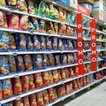 Pasillo con una variedad de productos snacks envasados en un hipermercado Carrefour.