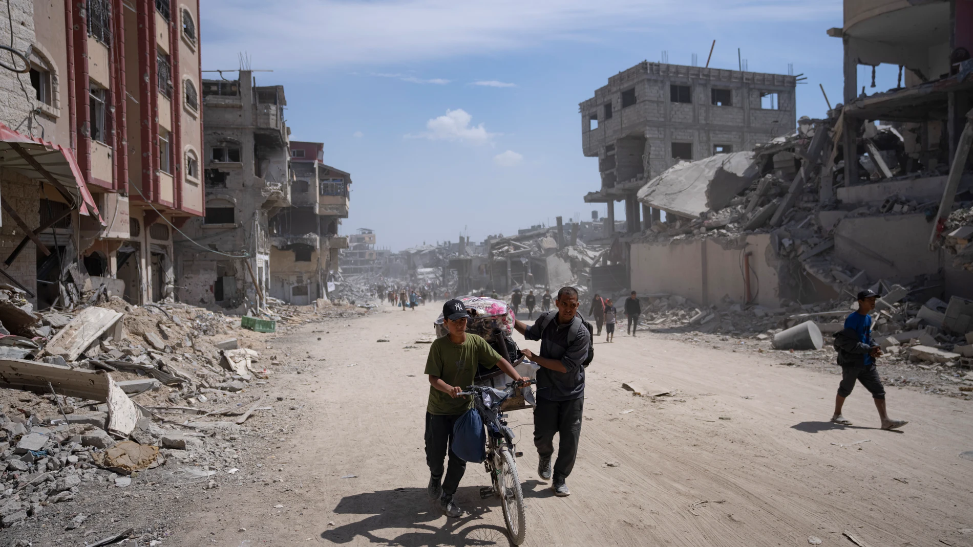 Palestinians walk through the destruction in the wake of an Israeli air and ground offensive in Khan Younis, southern Gaza Strip, Monday, April 8, 2024. Israel says it has withdrawn its last ground troops from the city, ending a four-month operation. (AP Photo/Fatima Shbair)