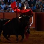 El torero Morante de la Puebla lidia el primero de la tarde durante el quinto festejo de la Feria de Abril, con toros de Juan Pedro Domecq, este jueves en la plaza de toros de la Real Maestranza de Sevilla. 