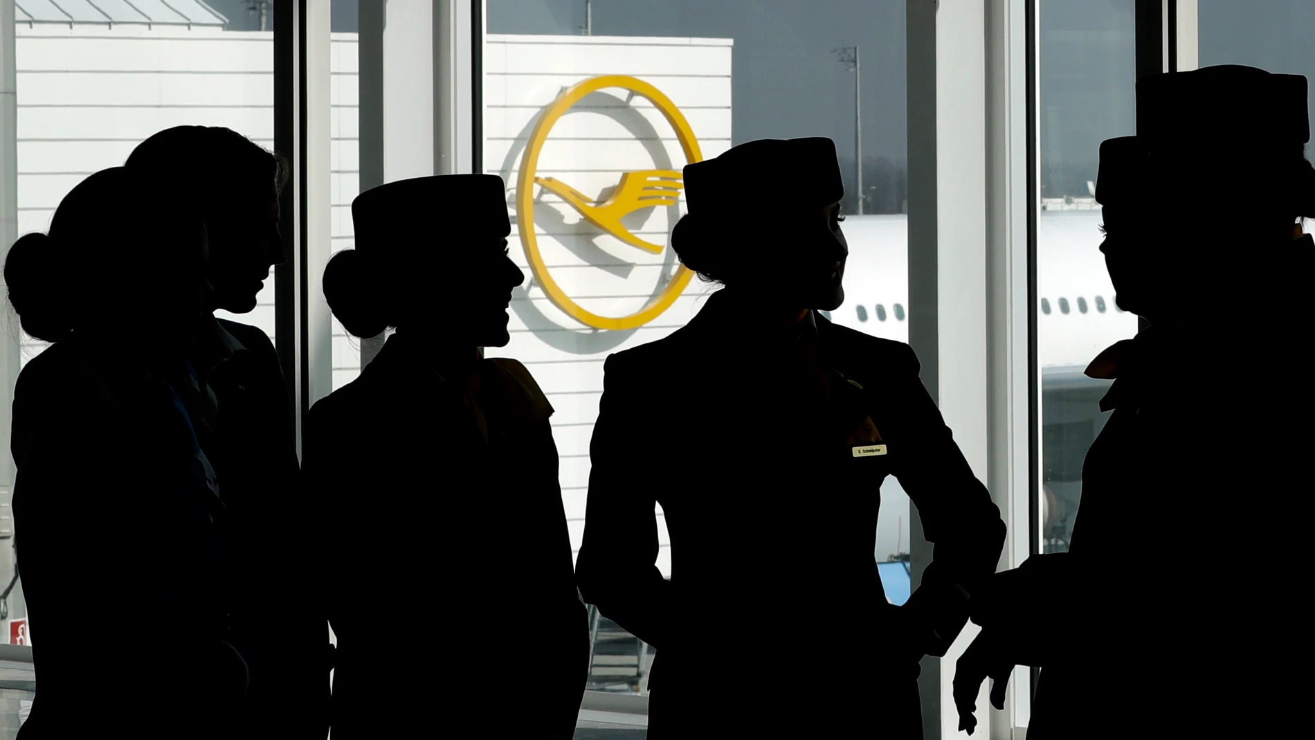 FILE - In this Thursday, March 16, 2017 file photo Lufthansa flight attendants silhouetted as they pose for a photograph on occasion of the company's annual press conference in Munich, Germany. Lufthansa and a union representing cabin crew reached a pay deal Thursday, concluding the last of several major disputes that have led to strikes recently at Germany's biggest airline and in the country's wider aviation sector. (AP Photo/Matthias Schrader,file)
