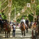 Paseo de caballos en el Real de la Feria en una calurosa jornada de domingo