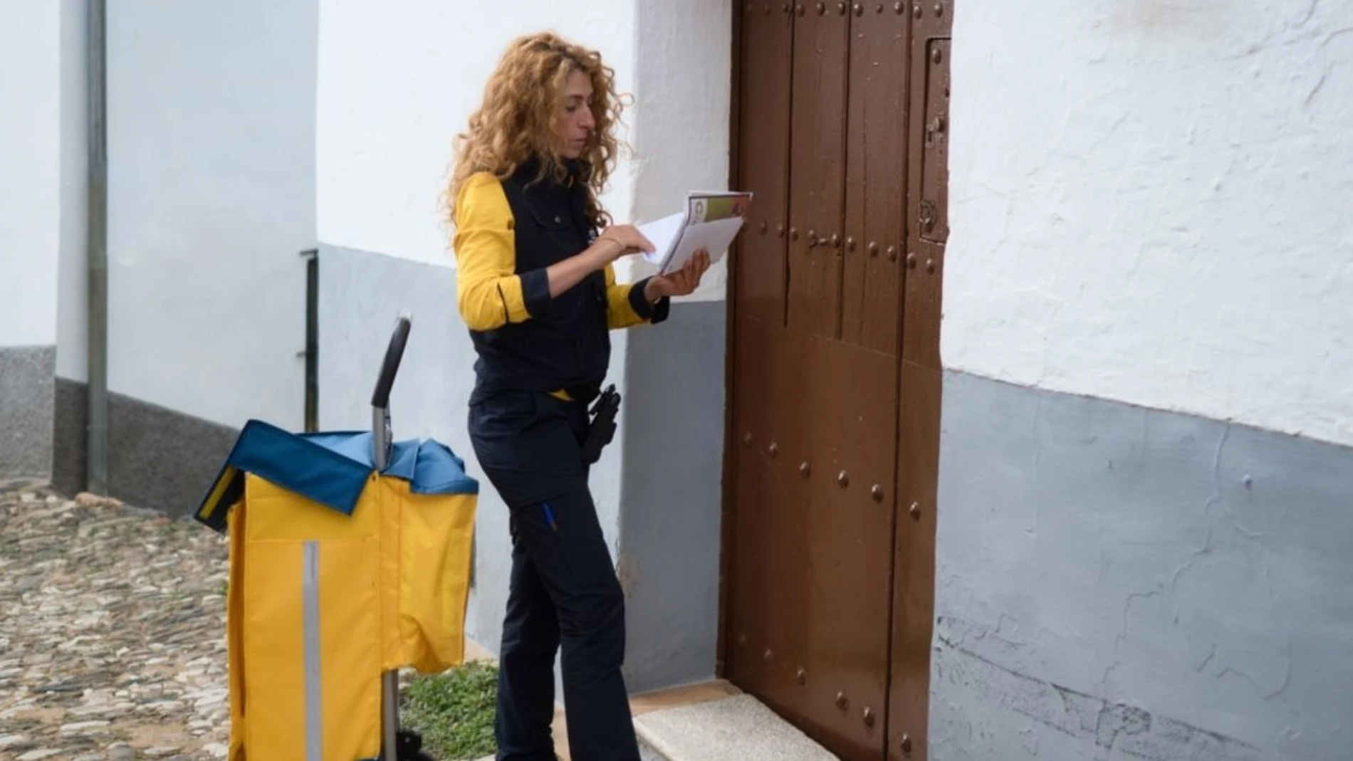 Una cartera de Correos haciendo el reparto en un pueblo