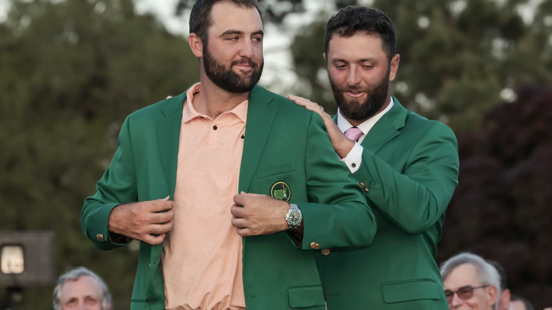 Jon Rahm inviste a Scottie Scheffler con la chaqueta verde