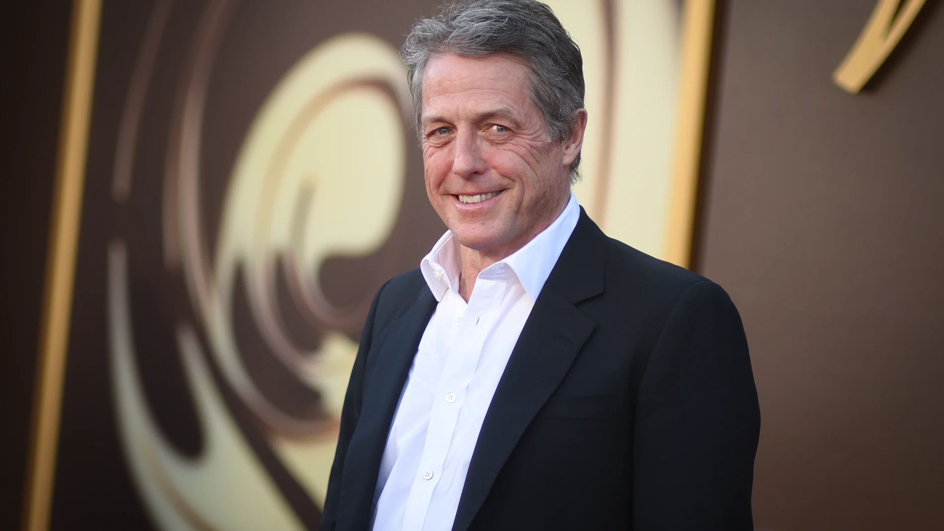 FILE - Hugh Grant arrives at the premiere of "Wonka" on Dec. 10, 2023, at Regency Village Theatre in Westwood, Calif. Hugh Grant says he received “an enormous sum of money” to settle a lawsuit accusing the publisher of The Sun tabloid of unlawfully tapping his phone, bugging his car and breaking into his home to snoop on him. (Photo by Richard Shotwell/Invision/AP, File)