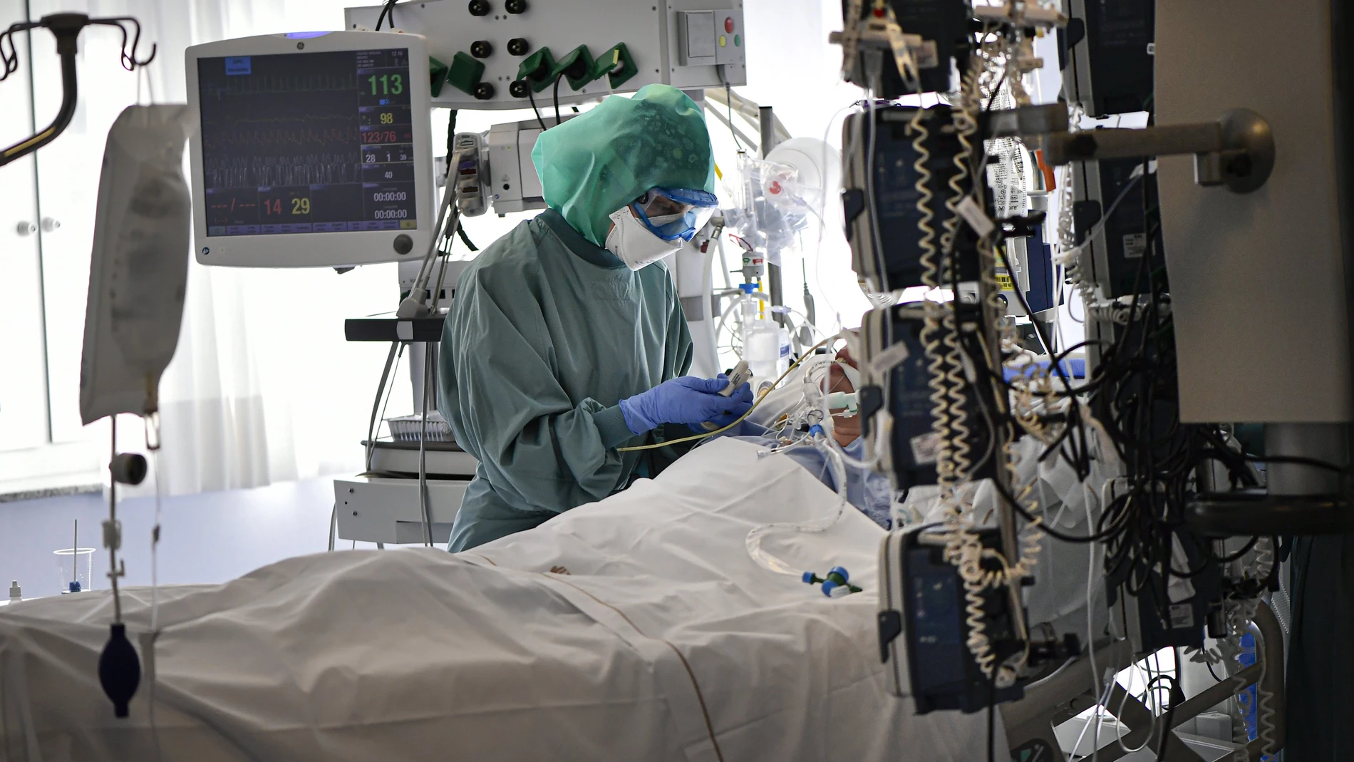 A medical staff member tends to a COVID-19 patient in the ICU department of the Clinica Universitaria, in Pamplona, northern Spain.