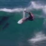 Un grupo de delfines acompaña y aúpa a la victoria a una surfista hawaiana en Australia