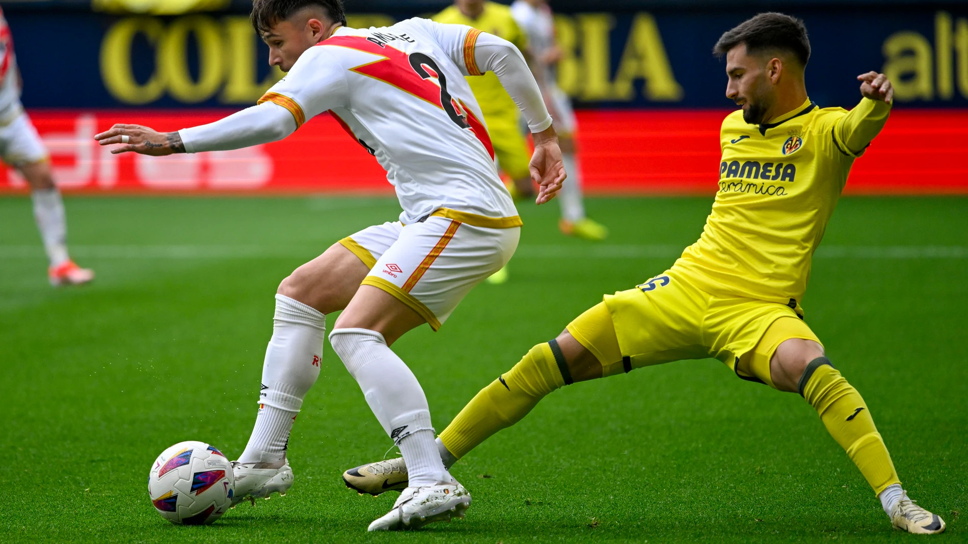 VILLARREAL (CASTELLÓN), 28/04/2024.- El defensa del Rayo Vallecano Andrei Ratiu (i) y el centrocampista del Villarreal Alex Baena durante el partido de LaLiga entre Villarreal y Rayo Vallecano, este domingo en el estadio de la Cerámica. EFE/ Andreu Esteban