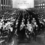 Storm Troopers raising their hands in salute as Adolf Hitler leads his staff down the aisle during opening of the National Socialist Party Convention in Nuremberg, Germany. In March 1933.
