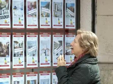 Una persona observa la oferta de pisos en alquiler de una oficina inmobiliaria de Barcelona. Una persona observa la oferta de pisos en alquiler de una oficina inmobiliaria de Barcelona.