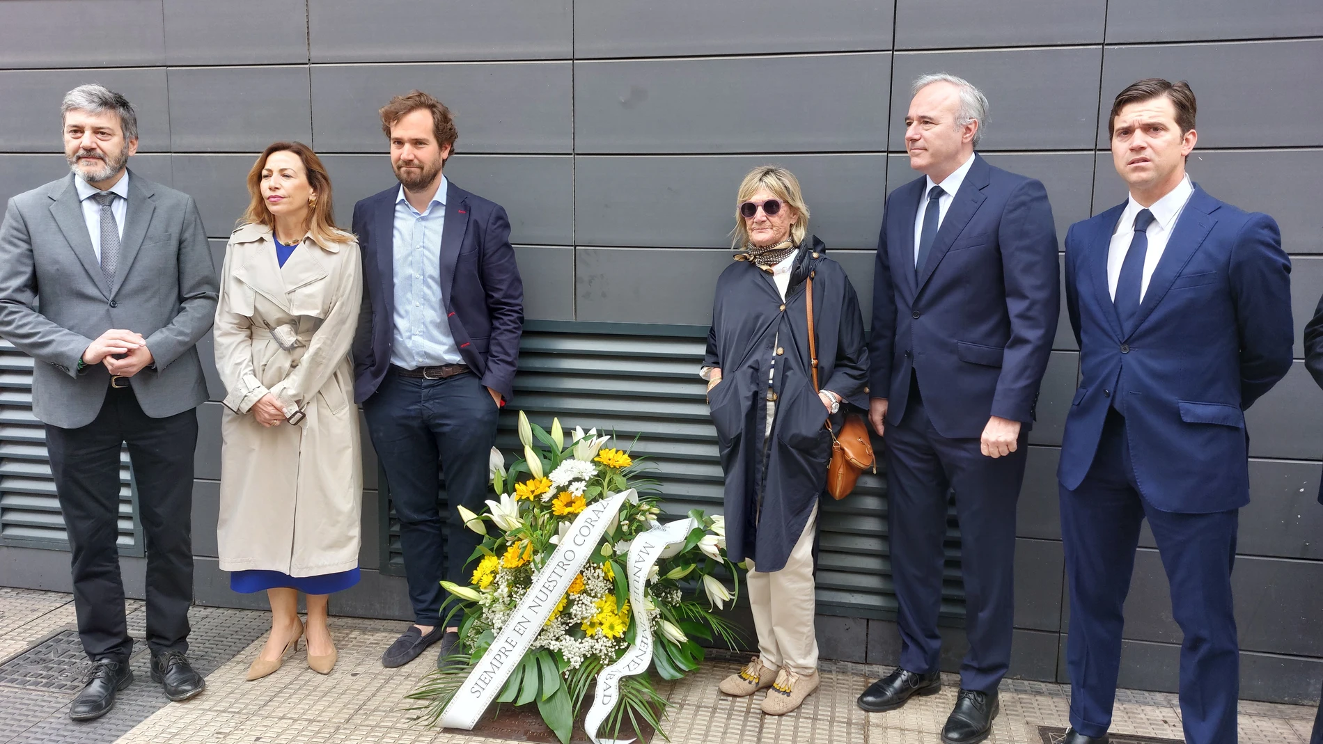 El presidente del PP de Aragón, Jorge Azcón, junto al hijo y a la viuda de Manuel Giménez Abad y otros dirigentes del partido, depositan una ofrenda floral en el lugar donde fue asesinado por ETA en 2001 el que fuera líder de los populares aragoneses. EUROPA PRESS 06/05/2024