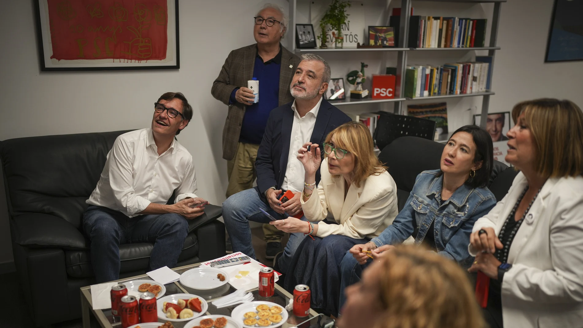 Socialist candidate Salvador Illa, left, watches early results on TV with other members of the PSC ( Socialist Party of Catalonia ) at the party headquarters in Barcelona, Sunday May 12, 2024.