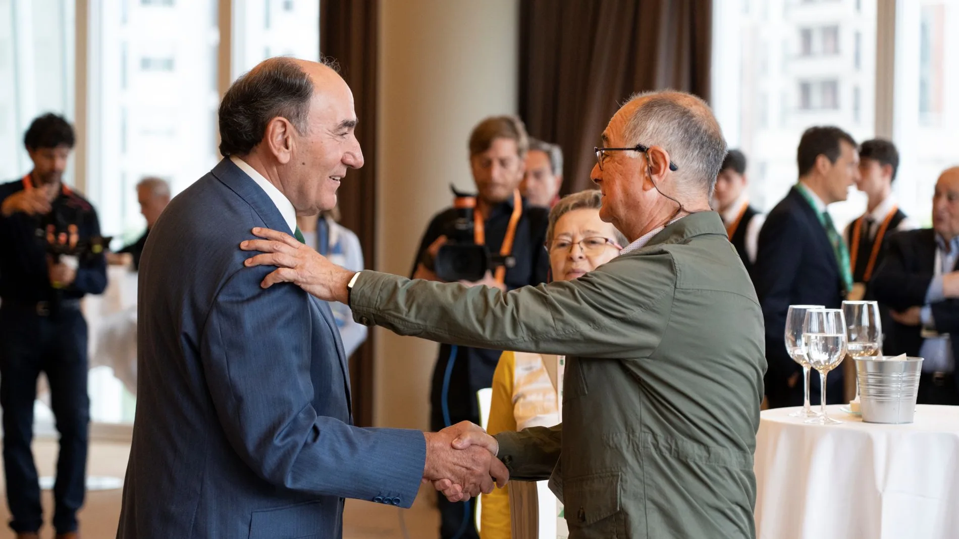 El presidente de Iberdrola, Ignacio Galán, y un accionista de la eléctrica se dan la mano