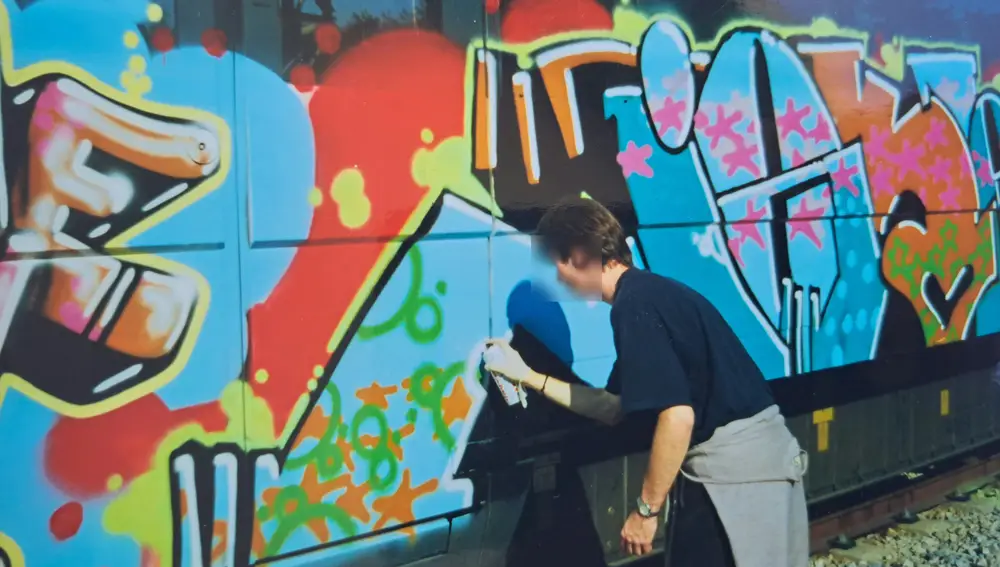 Un grafitero pintando un tren