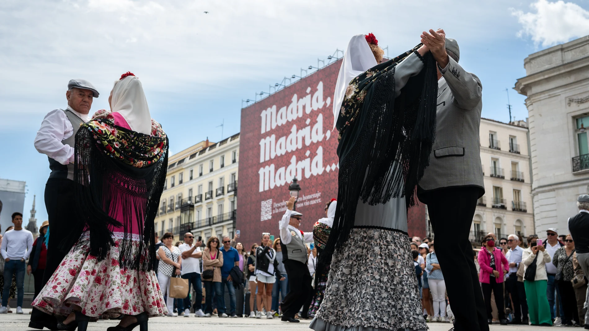 Parejas de chulapos bailando Chotis en la puerta del Sol de Madrid por las fiestas de San Isidro.