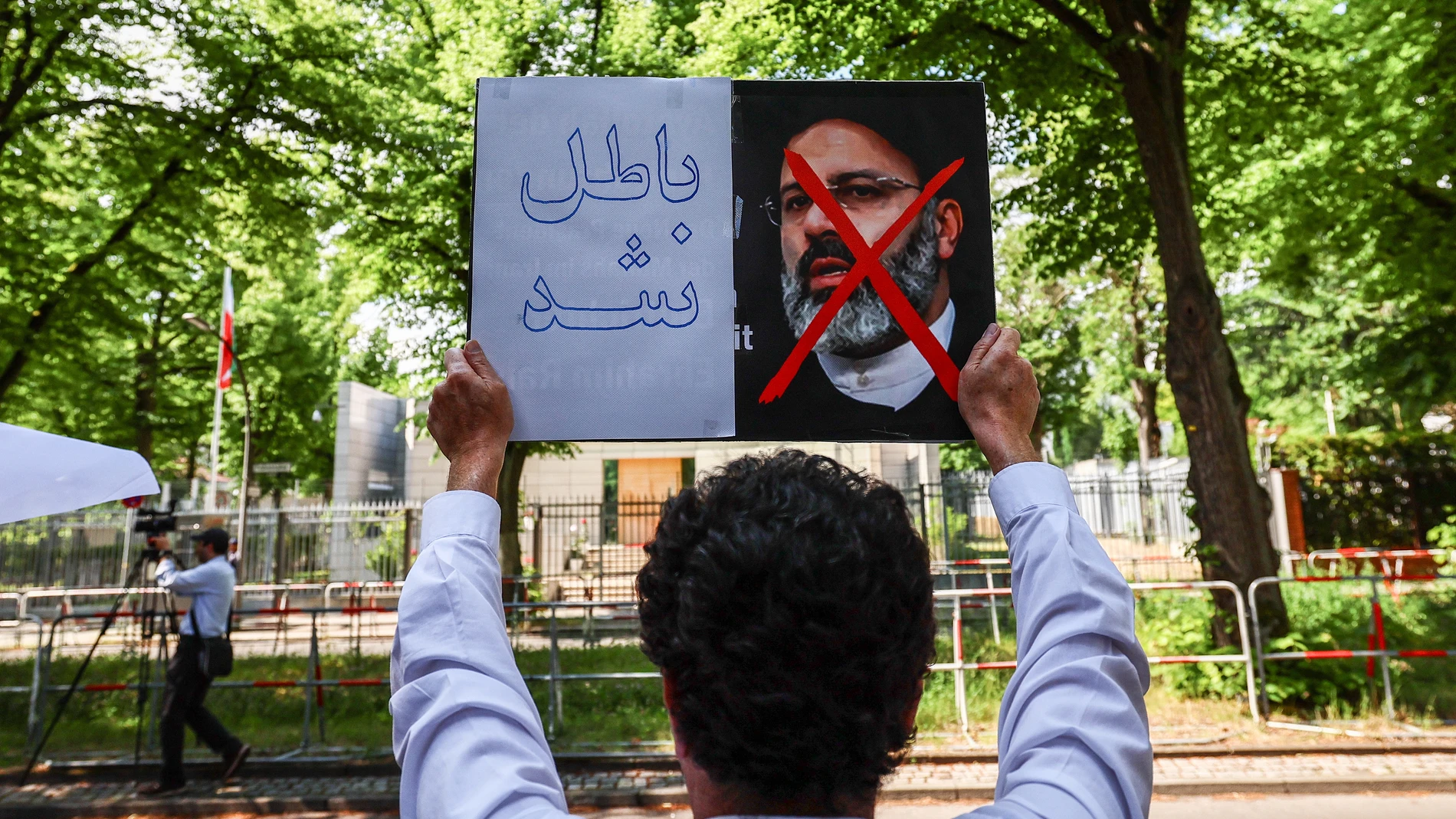 Berlin (Germany), 20/05/2024.- A protester holds a placard against Iran's President Ebrahim Raisi during a protest of the National Council of Resistance of Iran (NWRI) against the Iranian regime in front of the Embassy of the Islamic Republic of Iran, in Berlin, Germany, 20 May 2024. Iran's President Ebrahim Raisi, Foreign Minister Hossein Amir-Abdollahian and several others were killed in a helicopter crash on 19 May 2024, after an official visit in Iran's northwest near the border with Azer...