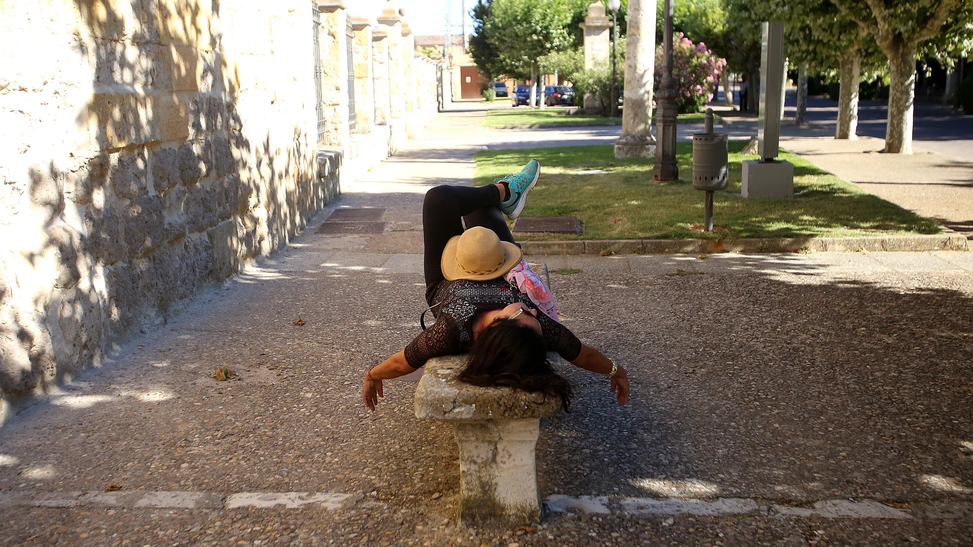 Una turista descansa en un banco junto al convento de San Francisco en Medina de Rioseco