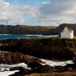 La ermita de la Virxe do Porto con el Faro de Punta Frouxeira, al fondo. 