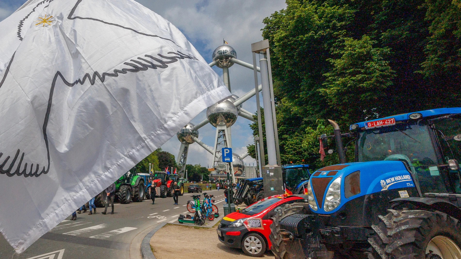 Brussels (Belgium), 04/06/2024.- A white flag with a peace dove is waved as farmers mainly from 'Farmers Defence Force' of The Netherlands but also from Belgium, Germany and Poland protest against the European Green Deal near the Atomium monument in Brussels, Belgium, 04 June 2024. The protest, ahead of the European elections on 09 June, is expected to be attended by hard-line farming associations and groups affiliated with the far-right. (Elecciones, Protestas, Bélgica, Alemania, Países Bajo...