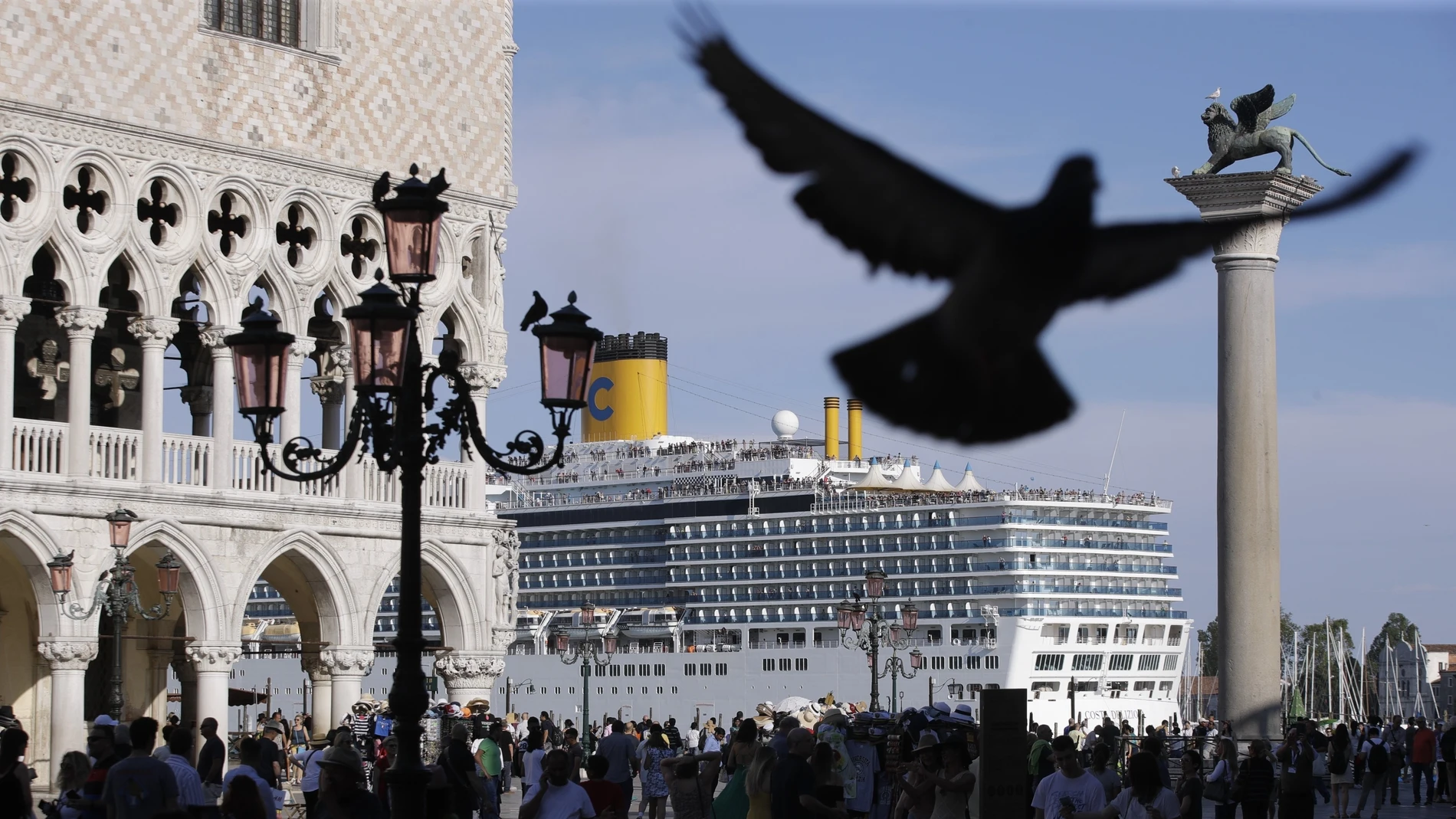 FILE - In this June 2, 2019 file photo, a cruise ship passes by St. Mark's Square filled with tourists, in Venice, Italy. Scientists say countries need to stop burning fossil fuels by 2050 at the latest to ensure global temperatures don't rise more than 1.5 degrees Celsius (2.7 Fahrenheit) this century. (AP Photo/Luca Bruno, File)