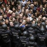 Agentes antidisturbios de la Policía Nacional forman un cordón de seguridad en los alrededores del colegio Ramón Llull de Barcelona. Policía Nacional y Guardia Civil han desplegado a sus agentes en varios colegios electorales de Barcelona para impedir el referéndum del 1-O, suspendido por el Tribunal Constitucional (TC), lo que ha originado momentos de tensión y algún forcejeo con las personas concentradas ante los locales. 
