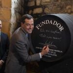 Juanma Moreno firma una una bota en las Bodegas Fundador