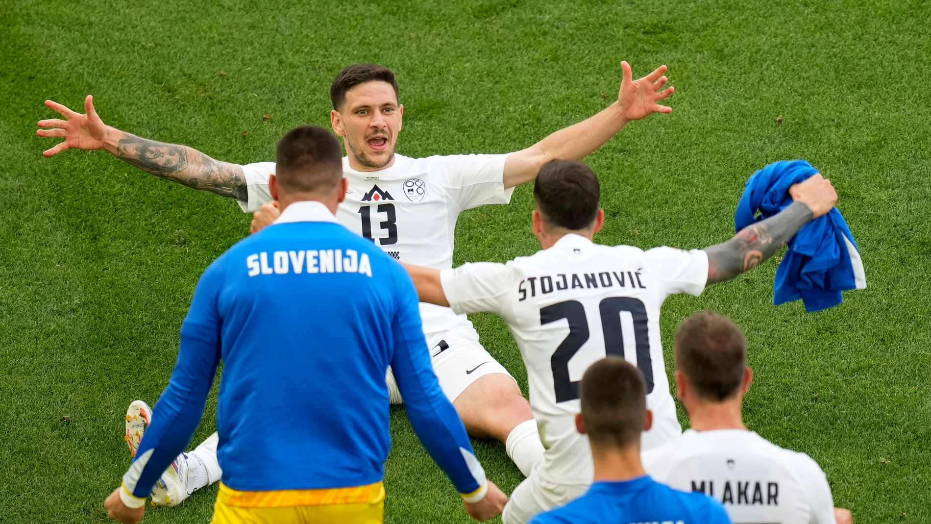 Slovenia's Erik Janza, on the ground, celebrates after scoring his side's first goal during a Group C match between Slovenia and Denmark at the Euro 2024 soccer tournament in Stuttgart, Germany, Sunday, June 16, 2024. (AP Photo/Ariel Schalit)