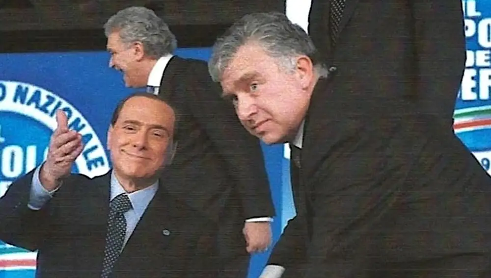 Berlusconi le indicándole a Roberto Gasparotti