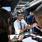 El «premier» británico, Rishi Sunak, habla con los periodistas en el autobús de campaña