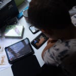 Un niño usa el teléfono móvil y una tablet