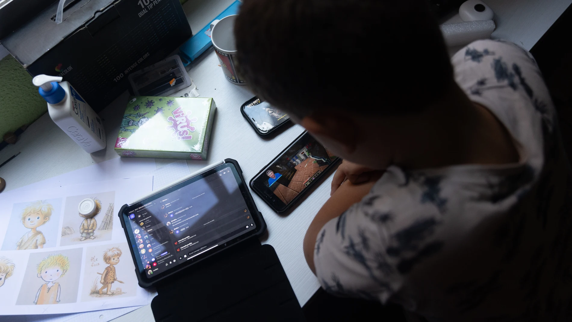 Un niño usa el teléfono móvil y una tablet