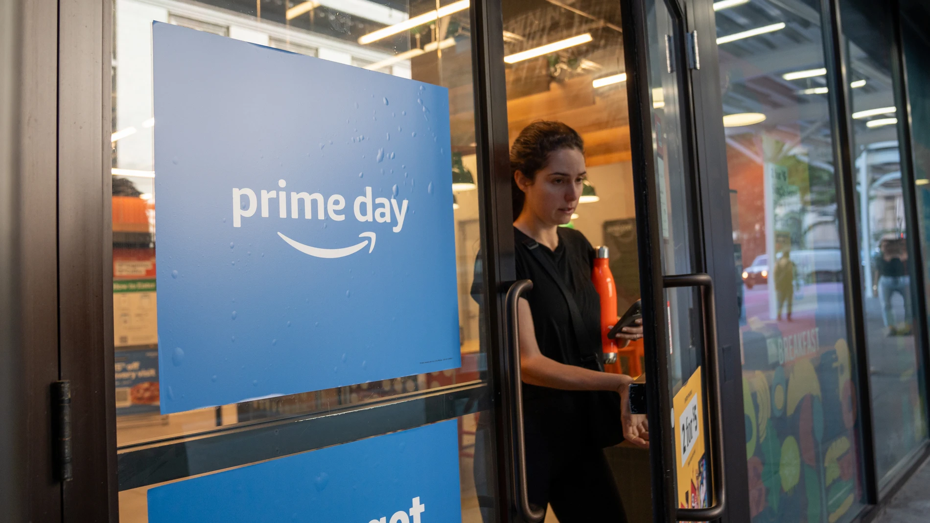 USA6169. NUEVA YORK (ESTADOS UNIDOS), 04/07/2024.- Una mujer sale de una tienda de la empresa Amazon, el 3 de julio en Manhattan, Nueva York (Estados Unidos). La compañía Amazon cumple mañana treinta años desde su fundación por Jeff Bezos en 1994, tres décadas en las que ha cambiado el comercio internacional y hasta el paisaje urbano de nuestras ciudades y que han aupado a la empresa a la élite de las más cotizadas del mundo: la pasada semana superó por primera vez los dos billones de dólares...